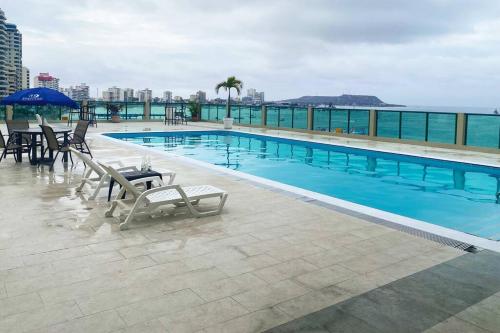 a large swimming pool with chairs and tables on a building at Suite en Colón Miramar con Netflix para 8 personas in Salinas