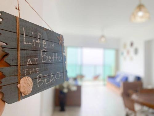 a person holding a sign that reads life is at the beach at Suite en Colón Miramar con Netflix para 8 personas in Salinas