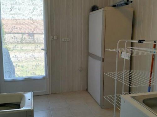 een keuken met een witte koelkast en een raam bij Gîte Les Clouzeaux, 3 pièces, 4 personnes - FR-1-426-288 in Les Clouzeaux