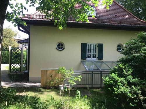 a small white house with a black fence at Ferienwohnung Villa Tana Miesbach in Miesbach