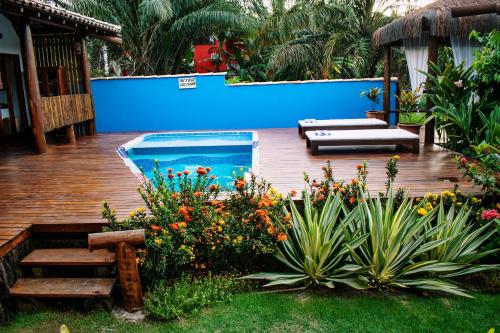 a backyard with a swimming pool and some plants at Barra Suítes in Barra Grande