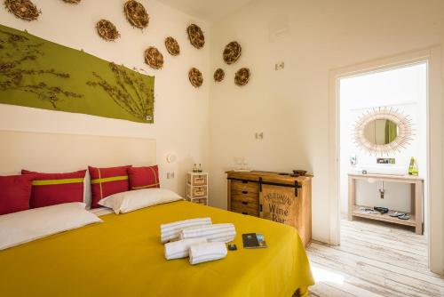 ein Schlafzimmer mit einem gelben Bett mit Handtüchern darauf in der Unterkunft Tiliguerta Glamping&Camping Village in Costa Rei