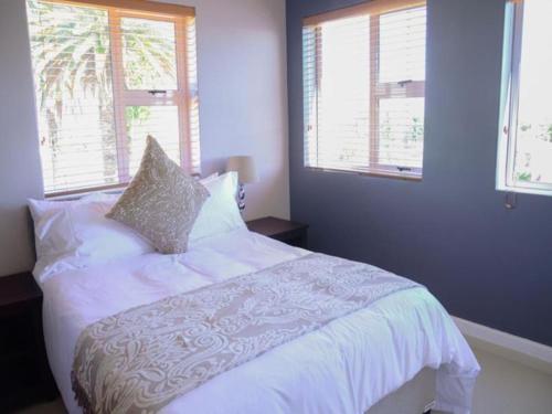 Cape Town的住宿－布魯克斯頓公寓，卧室配有白色床和2扇窗户