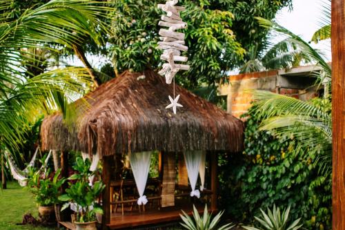 a hut with a thatched roof with a star decoration at Barra Suítes in Barra Grande