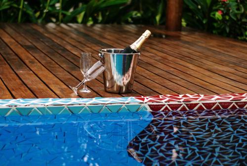 a bottle of wine in a bucket next to a swimming pool at Barra Suítes in Barra Grande