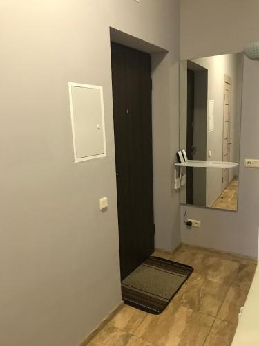 a hallway with a black door and a mirror at Apart Assistant on Smart Plaza in Kyiv