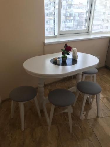 a white table with two chairs and a table with flowers on it at Apart Assistant on Smart Plaza in Kyiv