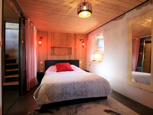 Un dormitorio con una cama con una almohada roja. en Gîte Saint-Julien-Chapteuil, 2 pièces, 2 personnes - FR-1-582-29, en Saint-Julien-Chapteuil