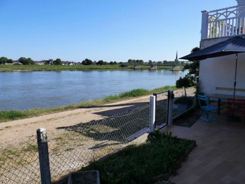 a fence next to a river with a building at Charmante Maison pour 6 à St Père-sur-Loire, Vue Loire - FR-1-590-178 in Saint-Père-sur-Loire