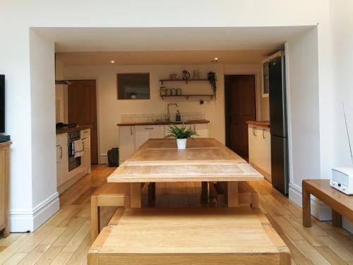 een keuken met een houten tafel in een kamer bij The Big Bristol House in Bristol