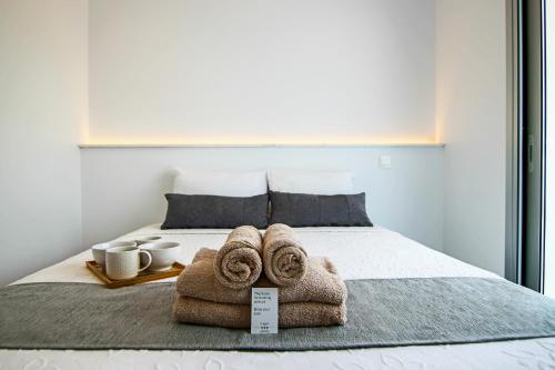ein Bett mit zwei Handtüchern und zwei Tassen drauf in der Unterkunft Phaedrus Living - Seaside Executive Flat Harbour 208 in Paphos