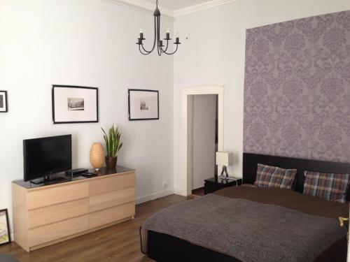 a bedroom with a bed and a tv on a dresser at Private Apartment Centertown in Budapest