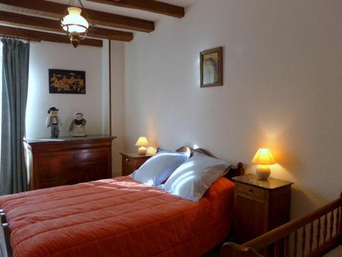 Schlafzimmer mit einem Bett mit roter Bettwäsche und weißen Kissen in der Unterkunft Gîte Bourmont-entre-Meuse-et-Mouzon-Bourmont, 4 pièces, 6 personnes - FR-1-611-58 in Bourmont