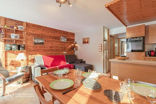 uma cozinha e sala de estar com uma mesa e um sofá em Résidence Le Pied des Pistes C6 em Lanslevillard
