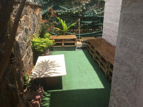 un jardín con suelo verde y banco en O soleil en Albion