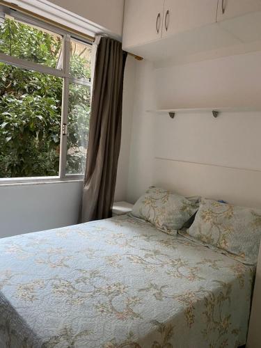 um quarto com uma cama e uma janela em Copacabana Apartment no Rio de Janeiro