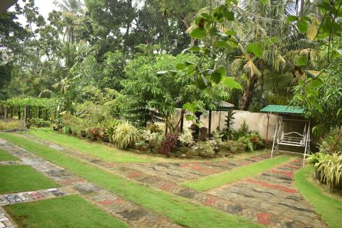a garden with a stone path and a fence at Geethani Tourist Home Polonnaruwa in Polonnaruwa