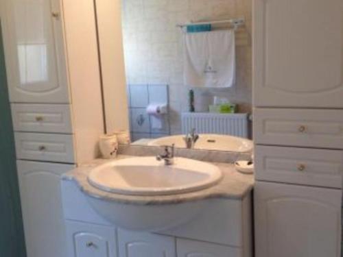 ein weißes Badezimmer mit einem Waschbecken und einem Spiegel in der Unterkunft Gîte Étain, 2 pièces, 2 personnes - FR-1-585-3 in Étain