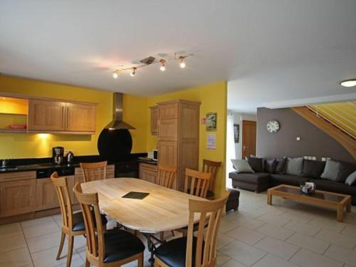 una cucina e un soggiorno con un tavolo e un divano di Gîte moderne à Rebeuville, proche Neufchâteau, 3 ch., accès PMR, pêche, WIFI, tout inclus - FR-1-589-157 a Rebeuville