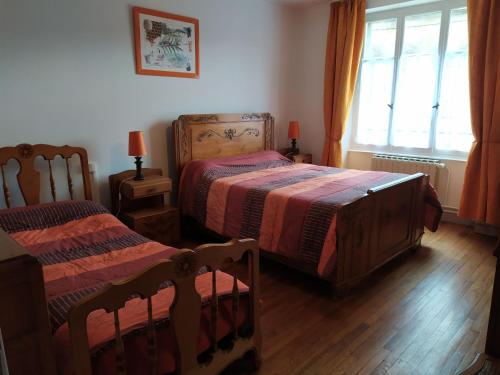 a bedroom with two beds and a window at Gîte convivial avec 3 chambres, proche du patrimoine historique, cour et équipements inclus - FR-1-589-38 in Aouze