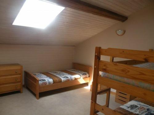 a bedroom with two bunk beds and a skylight at Gîte rénové avec grand terrain, proche d'Épinal, idéal pour balades et familiales - FR-1-589-87 in Dommartin-aux-Bois