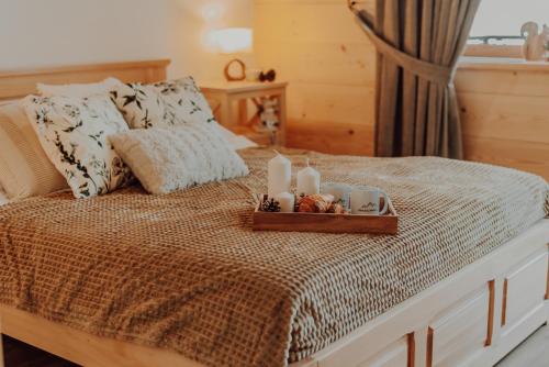 a bed with a tray with candles on it at Osada Snozka in Kluszkowce