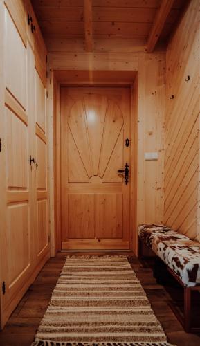 a room with a wooden door and a rug at Osada Snozka in Kluszkowce