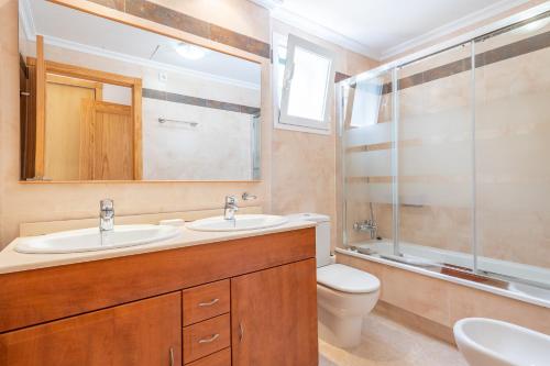 ein Badezimmer mit einem Waschbecken, einem WC und einem Spiegel in der Unterkunft Apartment Es Mirador 2 in Cales de Mallorca