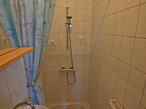a shower with a blue shower curtain in a bathroom at Gîte Hagécourt, 3 pièces, 4 personnes - FR-1-589-138 in Hagécourt