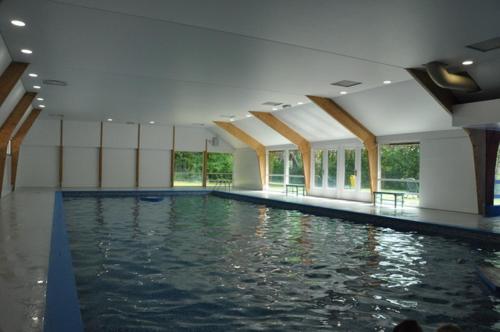 a large swimming pool with water in a building at Vakantiehuis Durbuy 'De witte vlinder' in Durbuy