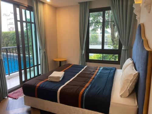 - une chambre avec un lit, des fenêtres et un balcon dans l'établissement Espana Condo Resort Pattaya EVT, à Jomtien Beach