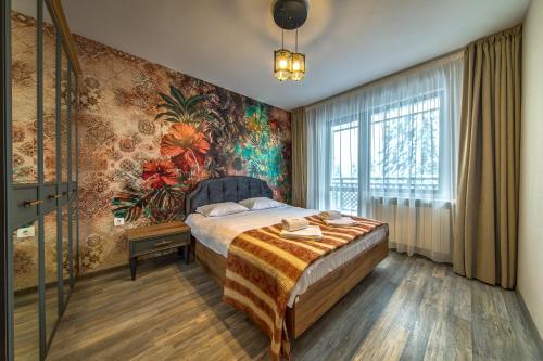 - une chambre avec un lit et un mur fleuri dans l'établissement Colors of Nature in Stylish Flat in Pamporovo, à Pamporovo