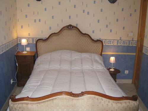 a large bed in a bedroom with two lamps at Gîte Domptail-en-l'Air, 2 pièces, 2 personnes - FR-1-584-9 