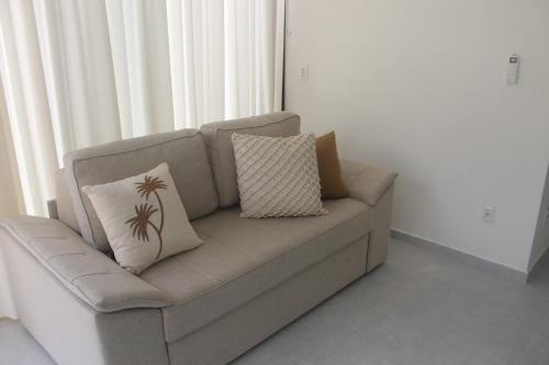 a couch with two pillows on it in a room at Fontes da Pipa by Liiv in Pipa