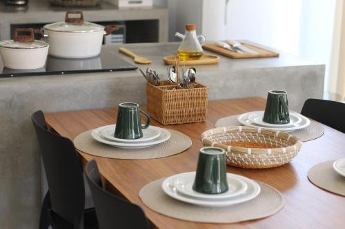 a wooden table with plates and hats on it at Fontes da Pipa by Liiv in Pipa
