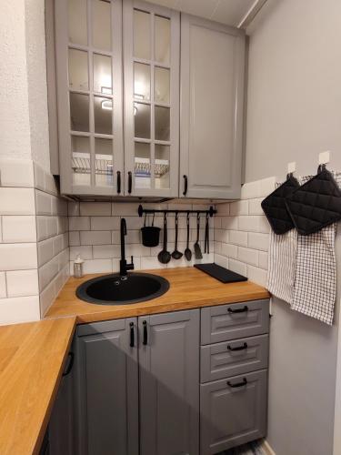 a kitchen with white cabinets and a sink at Nika Apartments in Imatra