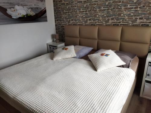 a bed in a bedroom with a brick wall at Ferienwohnung Harz Valley -Mit Fernblick in den Harz. in Goslar