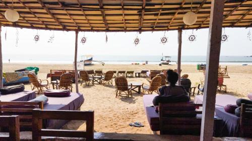 a woman sitting on a table on the beach at Drishti yoga international in Patnem