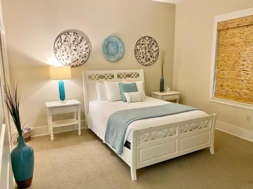 a bedroom with a white bed and two plates on the wall at 30A! Redfish Village Unit M2-424 is in the heart of it all!! in Santa Rosa Beach