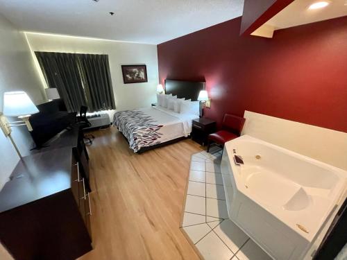 a hotel room with a bed and a red wall at Red Roof Inn Clyde in Clyde
