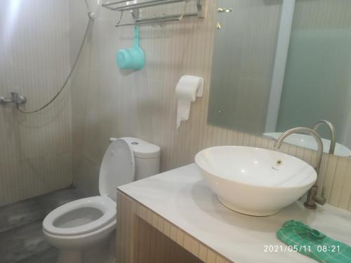ein Badezimmer mit einem weißen Waschbecken und einem WC in der Unterkunft Pondok Wammy Syariah in Cigasong