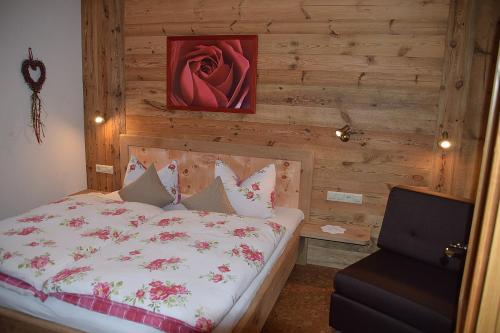 a bedroom with a bed with a wooden wall at Stoibhof Familie Klauser in Reit im Winkl