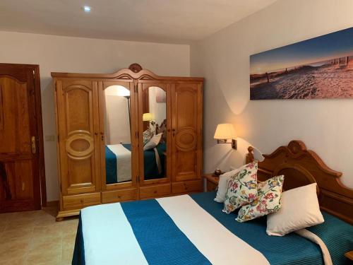a bedroom with a bed and a wooden cabinet at El Cercado in Icod de los Vinos