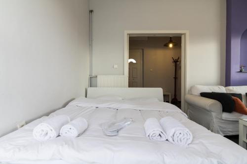 a white bed with towels on top of it at An adorable Apartment in Athens in Athens