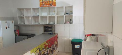 a kitchen with white cabinets and a counter top at Surf House Hostel in Santa Maria