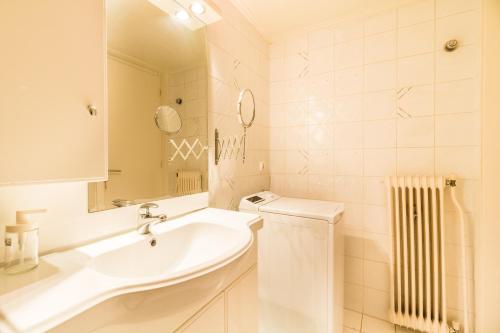 アテネにあるOne-Bedroom Apartment - Kolonakiの白いバスルーム(シンク、鏡付)