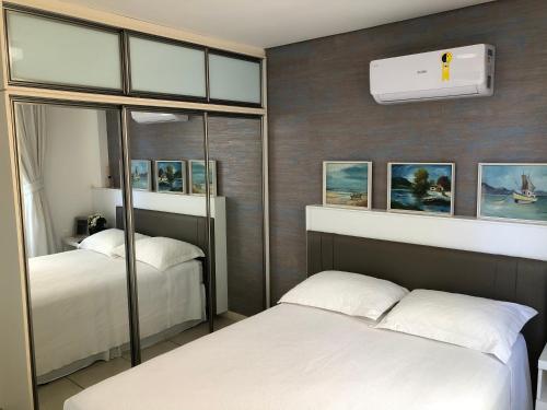 a bedroom with two beds and a wall with pictures at Vila do Porto Resort - Charme e Conforto! in Aquiraz