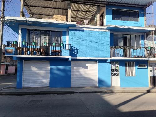 un edificio azul con sillas en el balcón en Hospedaje La Cienega, en Zacatlán