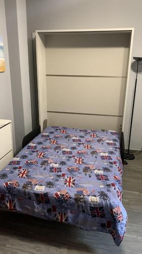 a bed with a blue quilt on it in a room at Casa di Ema in Sanremo