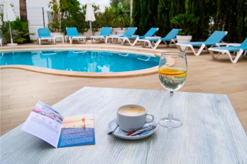 a table with a cup of coffee and a glass of wine at INNER Hotel Rupit "Adults Only" in Cala d´Or